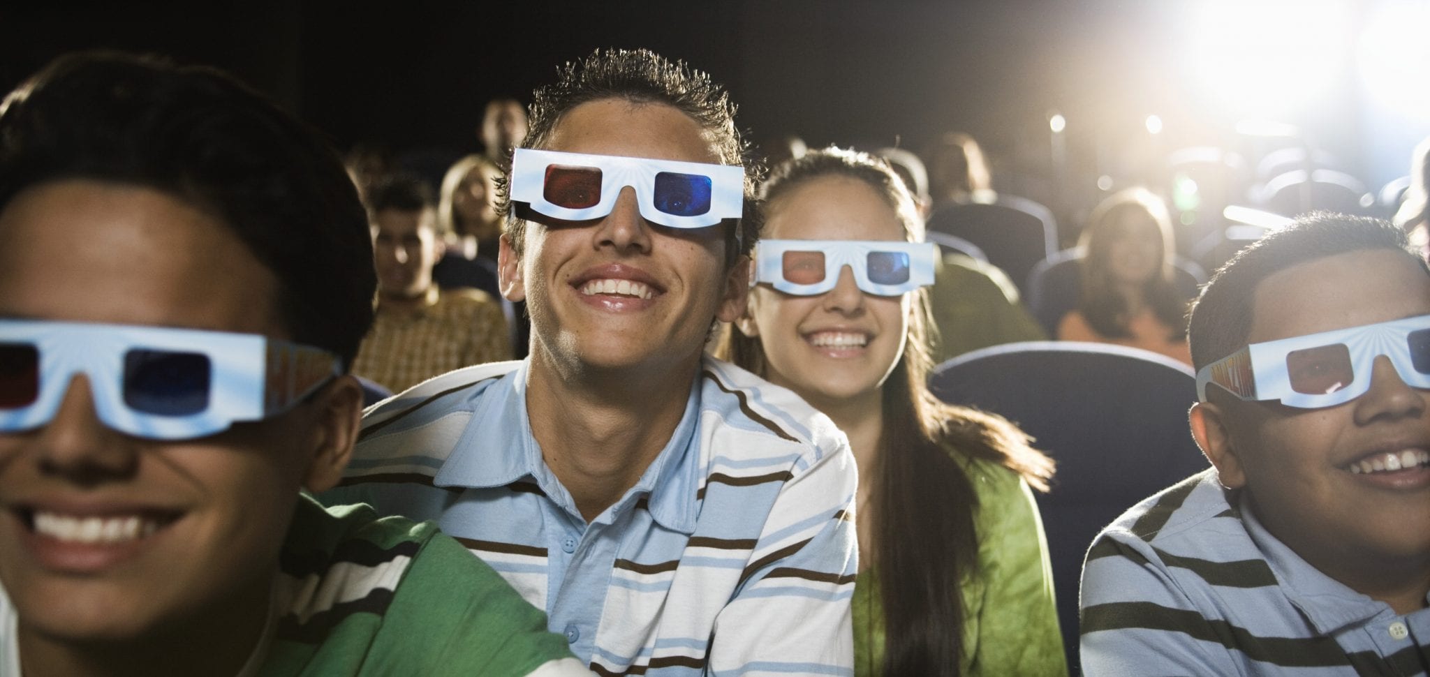 Movie ongoers are wearing 3D glasses & smiling